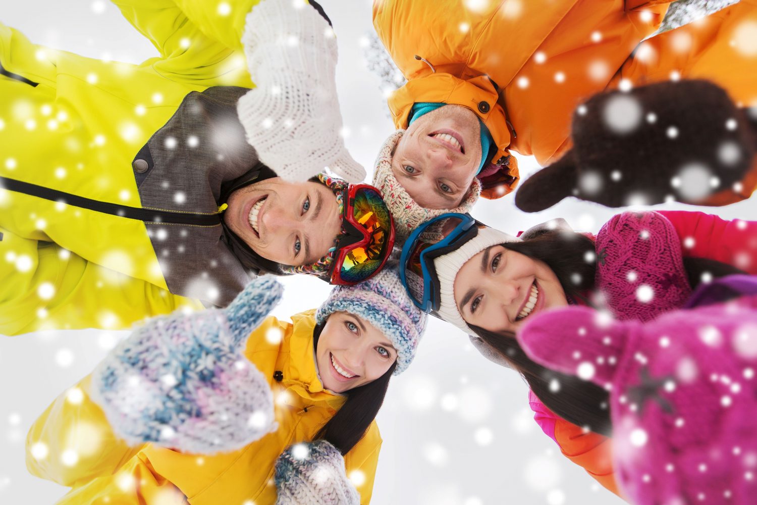 Group of smiling skiers enjoying fresh powder on a sunny ski slope